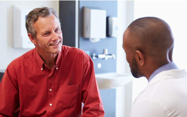 A surgeon consulting with a male patient about the ActaStim bone growth stimulation system